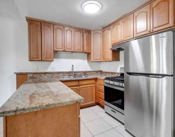 a kitchen with wooden cabinets and stainless steel appliances
