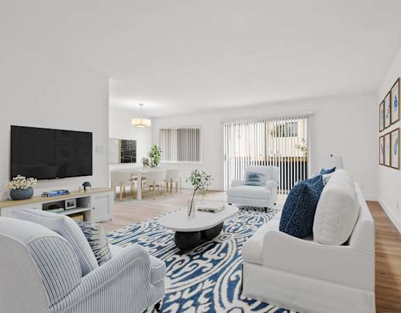 a living room with blue and white furniture and a tv