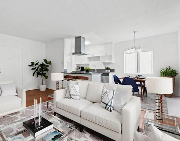 a living room with white couches and a glass coffee table