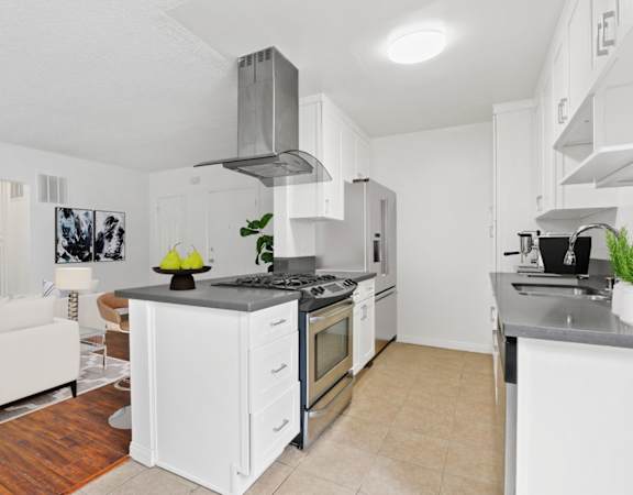 a kitchen with white cabinets and a stove top oven
