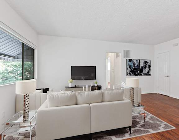 a living room with a white couch and a tv