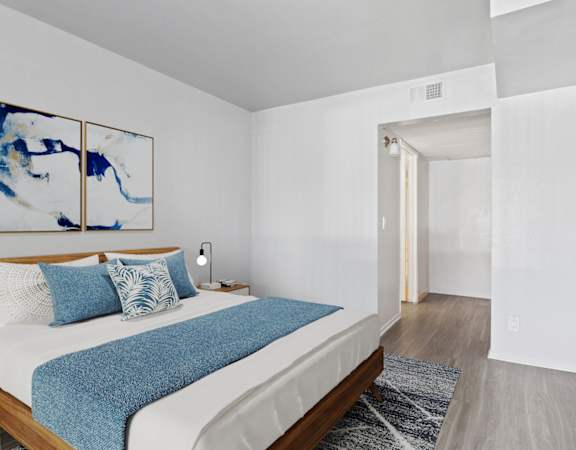 a bedroom with a white bed and a blue blanket