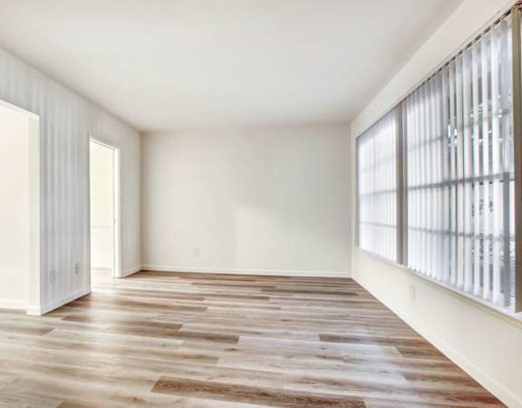 a bedroom with hardwood floors and white walls