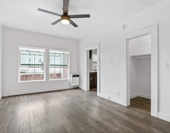 an empty living room with a ceiling fan