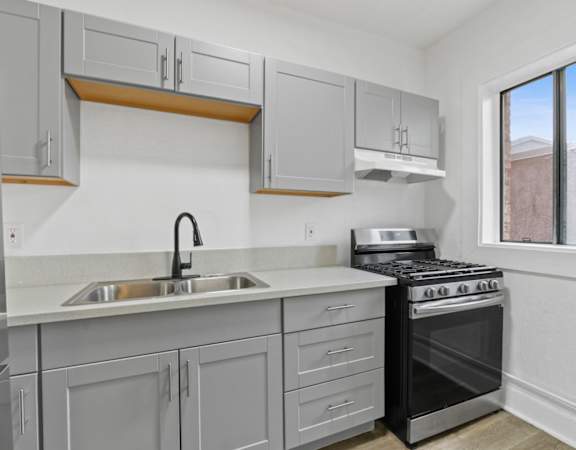 a kitchen with gray cabinets and a black stove top oven