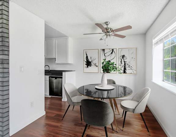 a dining room with a table and chairs and a ceiling fan
