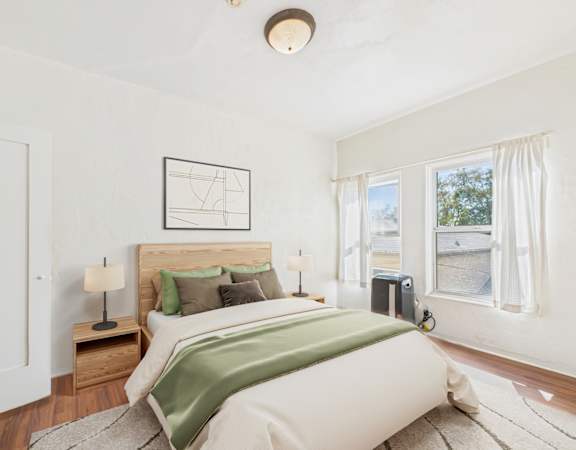 A bedroom with a large bed and a window overlooking a street.