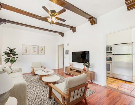 A living room with a wooden ceiling fan and a television.