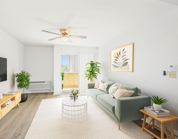 a living room with a green couch and a ceiling fan
