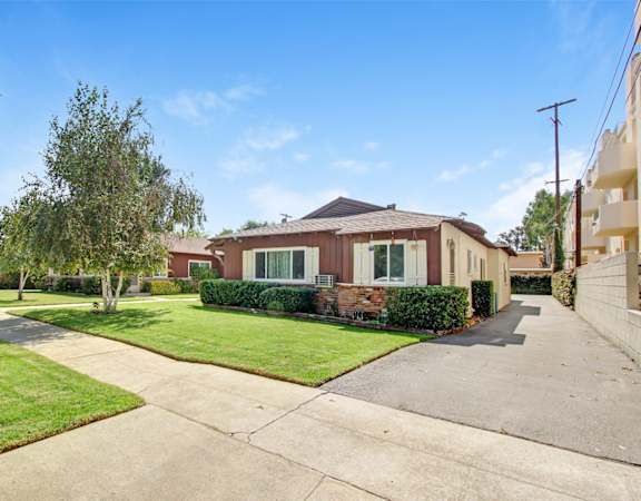 a house with a sidewalk and lawn in front of it
