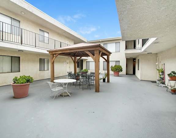 a patio with a table and chairs and a pergola