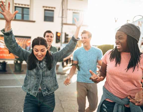 group of young people laughing and dancing in the street