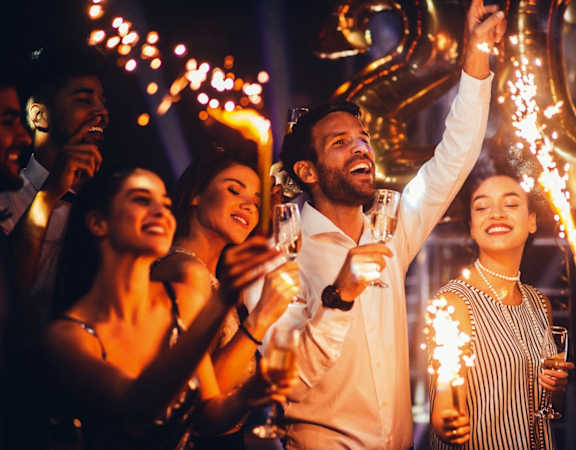 a group of people celebrating at a party with sparklers