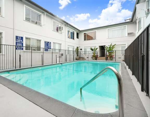 a swimming pool in front of a white building