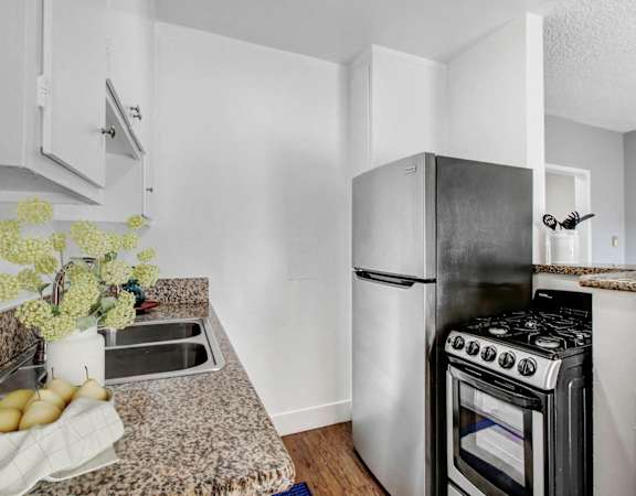 A kitchen with a black stove top oven and a white refrigerator.