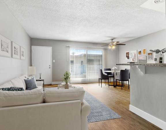A living room with a couch, a table, and a ceiling fan.