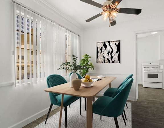 A dining room with a table, chairs, and a ceiling fan.