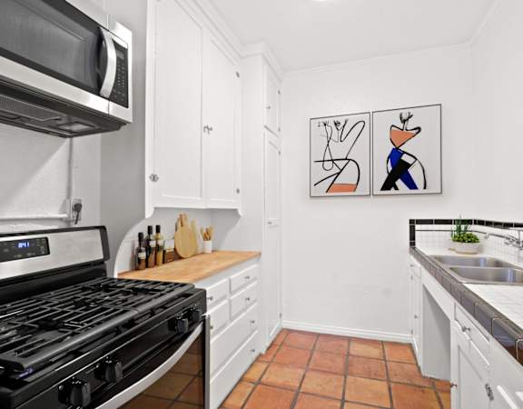 a kitchen with a stove and a sink and a microwave