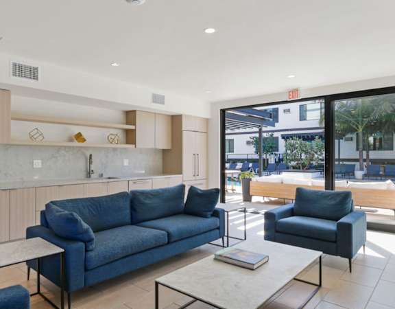 a living room with blue couches and chairs