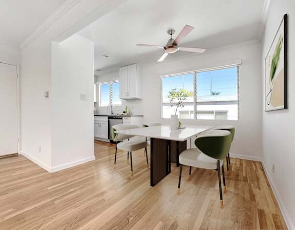 A room with a dining table and chairs.