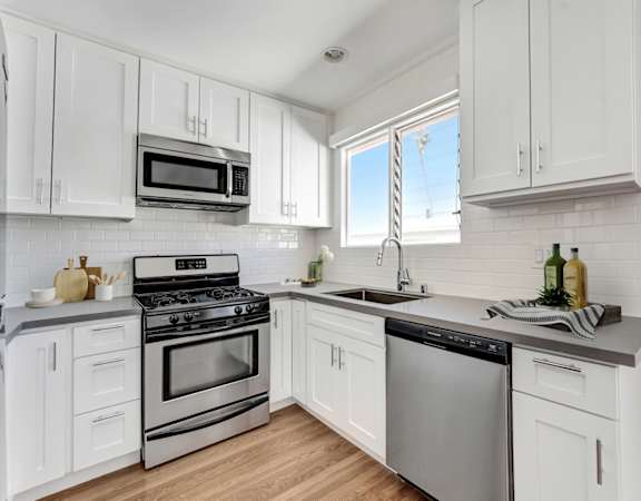 A kitchen with white cabinets and stainless steel appliances.
