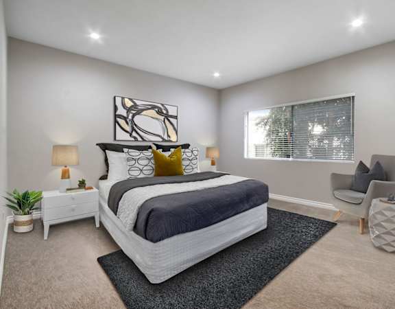 a bedroom with grey walls and a large window