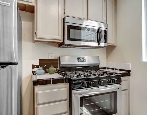 a kitchen with white cabinets and stainless steel appliances