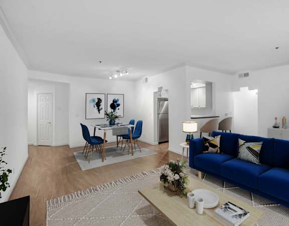 a living room with a blue couch and a table with chairs