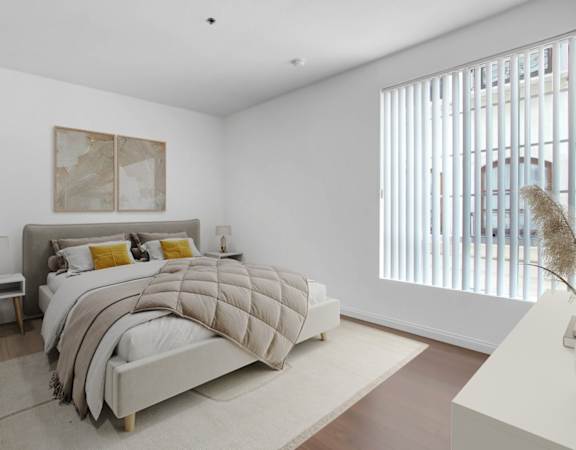 a bedroom with a bed and a large window