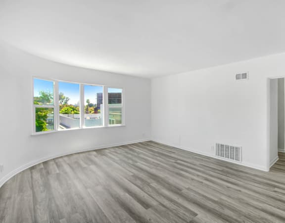 an empty living room with white walls and wood floors