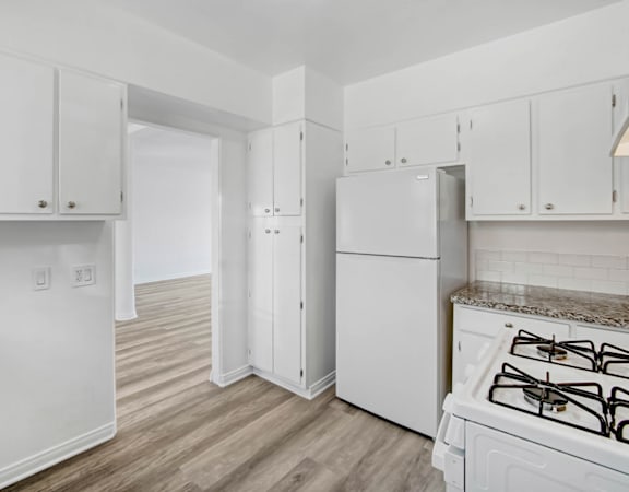 a white kitchen with white appliances and white cabinets