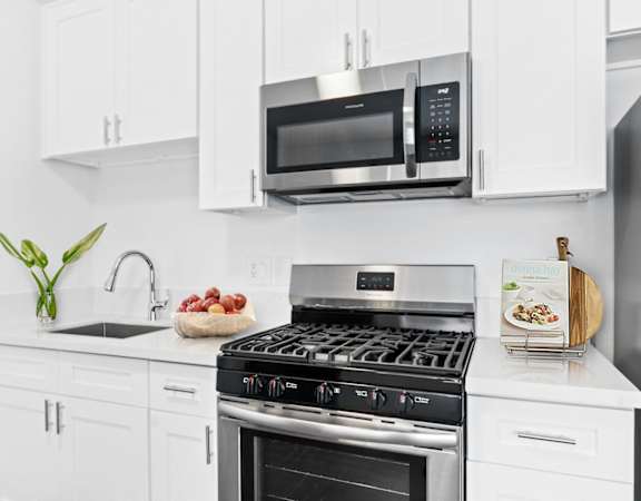 a kitchen with white cabinetry and stainless steel appliances