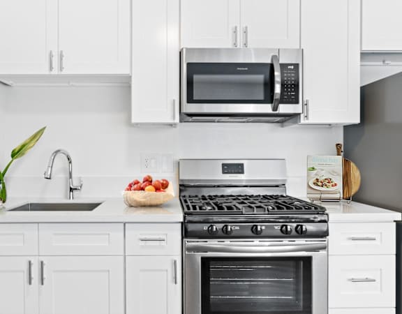 a kitchen with white cabinetry and stainless steel appliances