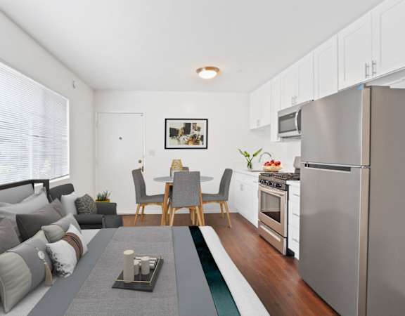 a living room with a couch a table and a refrigerator