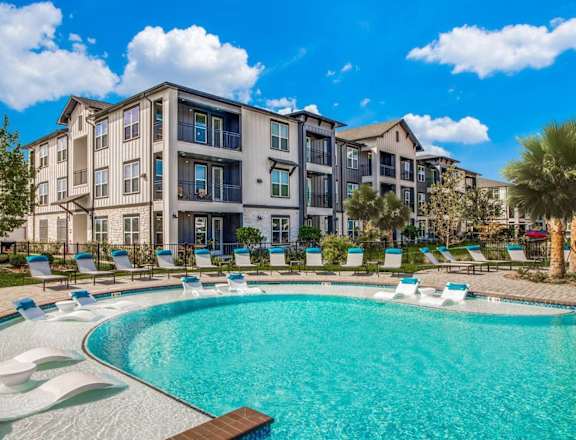 a large swimming pool with an apartment building in the background