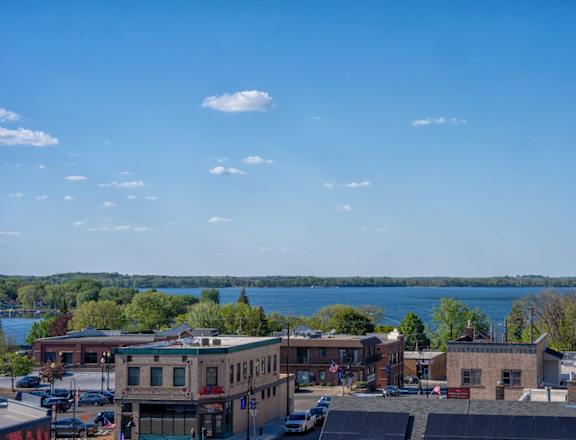 A view of a town with a lake in the background.