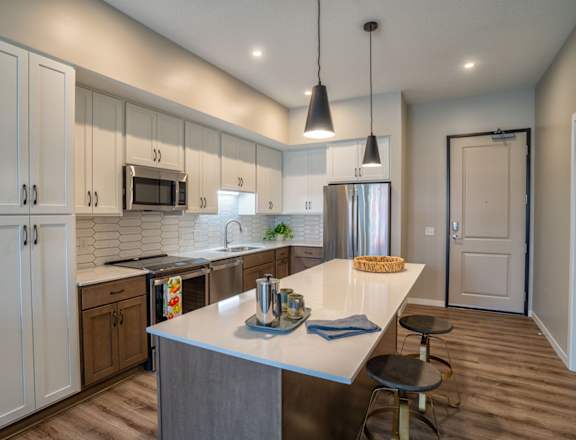A kitchen with a white counter top and a large island.