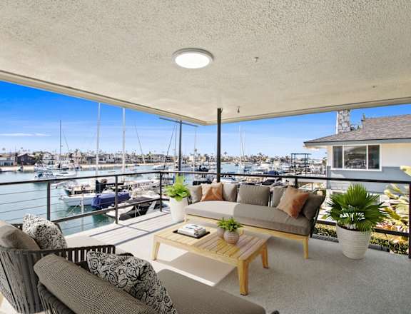 a living room with a balcony overlooking a marina