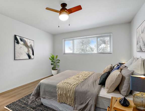 a bedroom with a large bed and a ceiling fan
