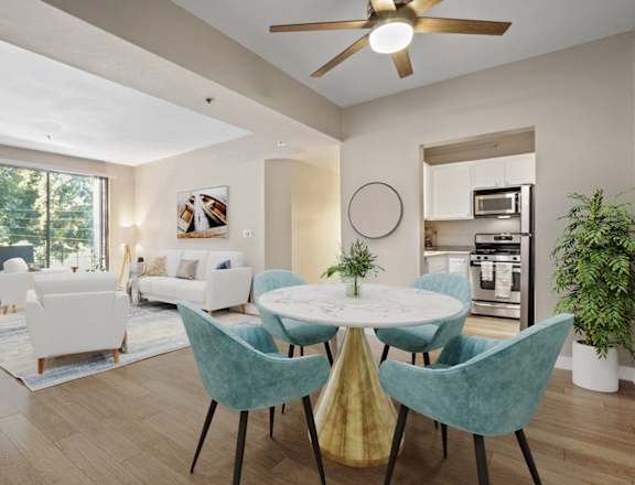 A modern dining room with a white table and blue chairs.