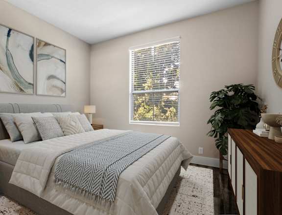A bedroom with a large bed and a painting on the wall.