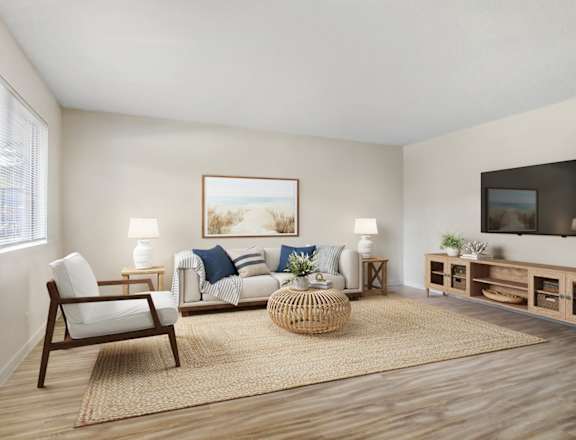 A living room with a sofa, chair, and a painting on the wall.