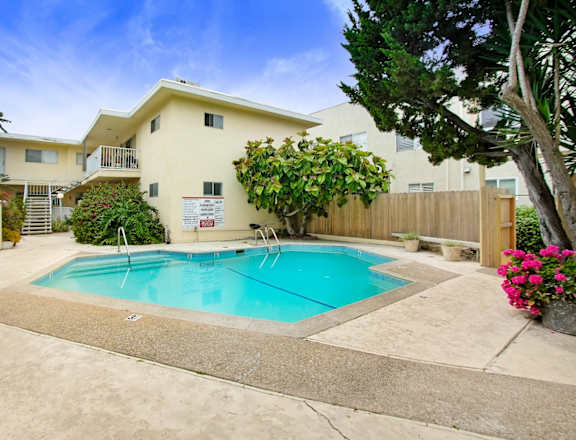 a swimming pool in front of a house with a pool