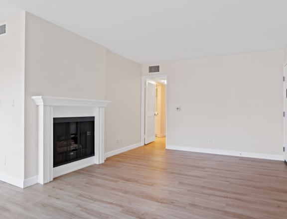 a bedroom with a fireplace and hardwood floors