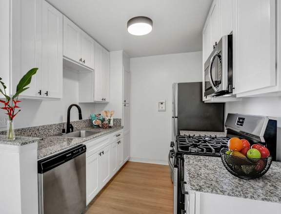 a kitchen with white cabinetry and granite countertops