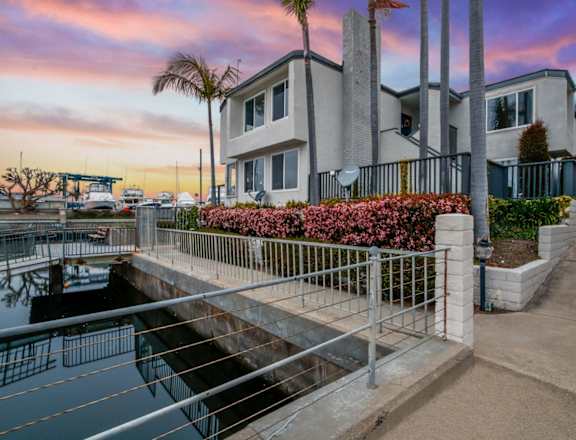 a house overlooking a body of water with a sunset in the background