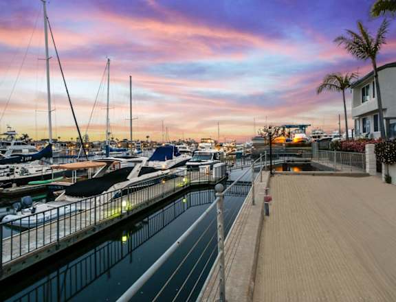 a marina with boats and yachts at sunset