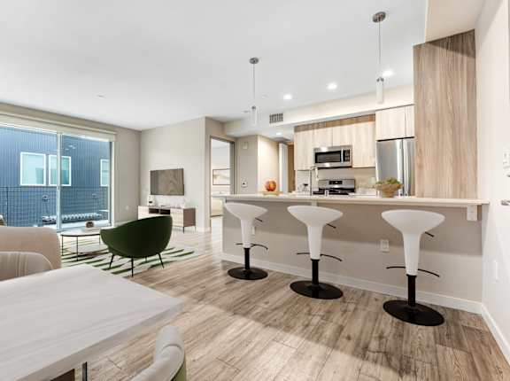 A modern kitchen with a white table and chairs.at The Blvd Lofts, Encino, CA