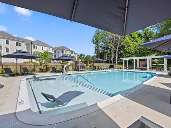 our apartments have a resort style pool with chairs and umbrellas