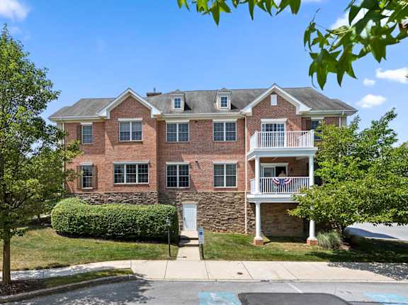 A red brick apartment building with a flag on the balcony.